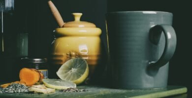 beige ceramic jar beside grey ceramic pitcher and sliced lemon fruit